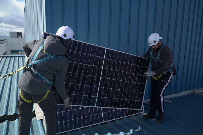 Instaladores cargando con placa solar fotovoltaica